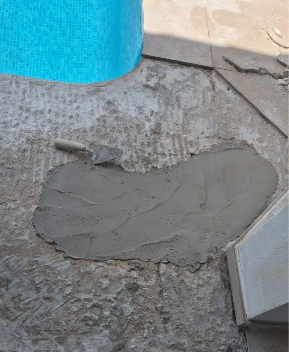 Aplicación de mortero para la reposición del acabado junto al borde de la piscina